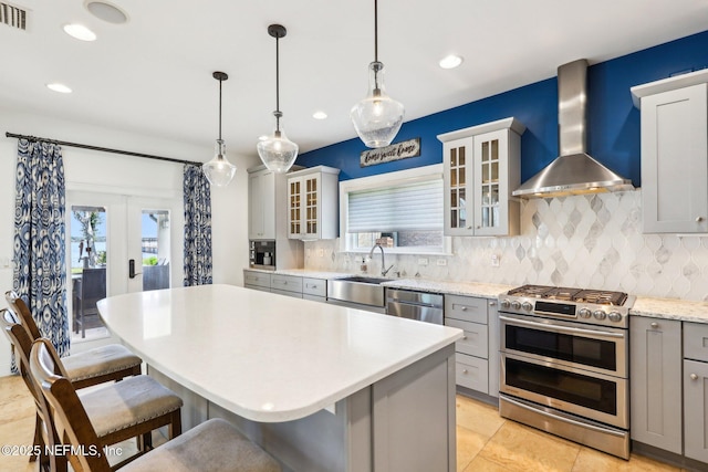 1833 N Lakeshore Dr, Fleming Island, FL 32003 - kitchen featuring decorative backsplash, gray cabinets, appliances with stainless steel finishes, and wall chimney range hood