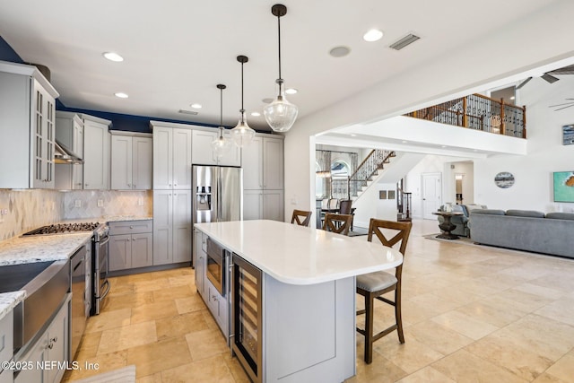 1833 N Lakeshore Dr, Fleming Island, FL 32003 - kitchen with a breakfast bar area, backsplash, visible vents, beverage cooler, and recessed lighting