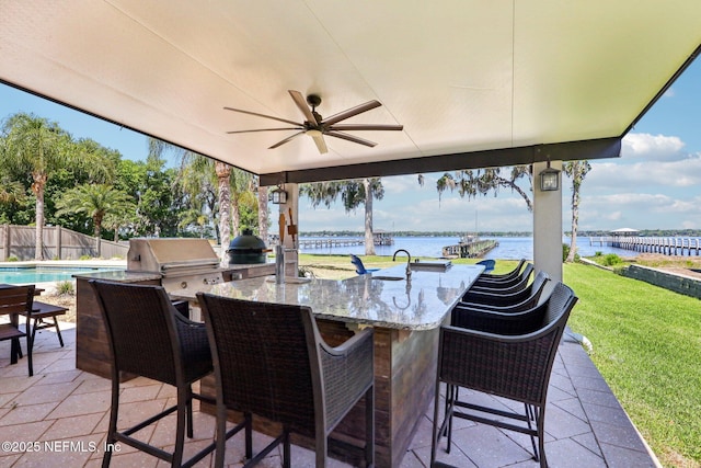 1833 N Lakeshore Dr, Fleming Island, FL 32003 - view of patio / terrace featuring fence, outdoor wet bar, area for grilling, a water view, and a ceiling fan