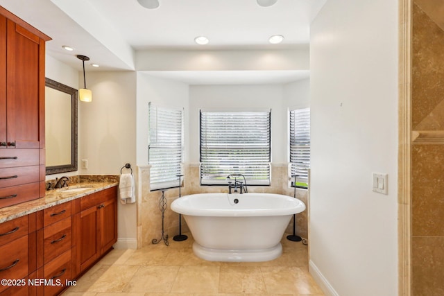 1833 N Lakeshore Dr, Fleming Island, FL 32003 - bathroom with vanity, tile walls, a freestanding bath, and a wainscoted wall