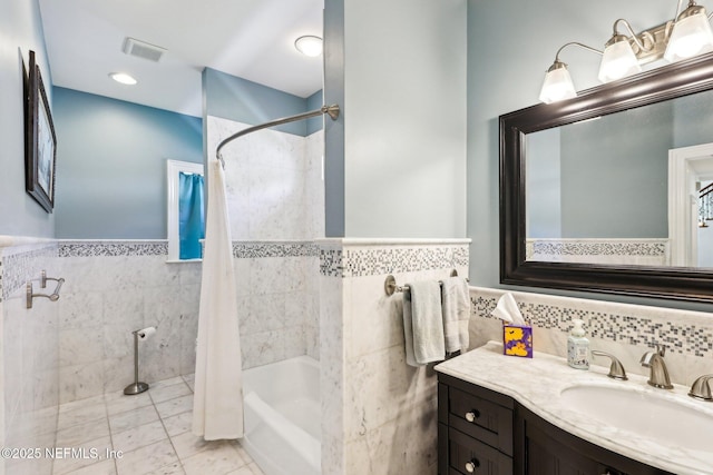 1833 N Lakeshore Dr, Fleming Island, FL 32003 - bathroom with vanity, shower / tub combo with curtain, a wainscoted wall, tile walls, and visible vents