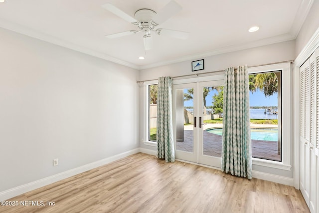 1833 N Lakeshore Dr, Fleming Island, FL 32003 - unfurnished room featuring crown molding, baseboards, a water view, french doors, and light wood finished floors