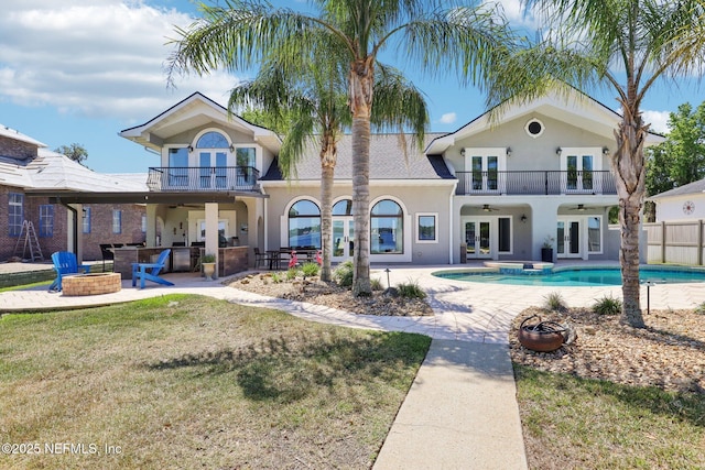 1833 N Lakeshore Dr, Fleming Island, FL 32003 - back of house featuring a ceiling fan, french doors, a balcony, and an outdoor fire pit