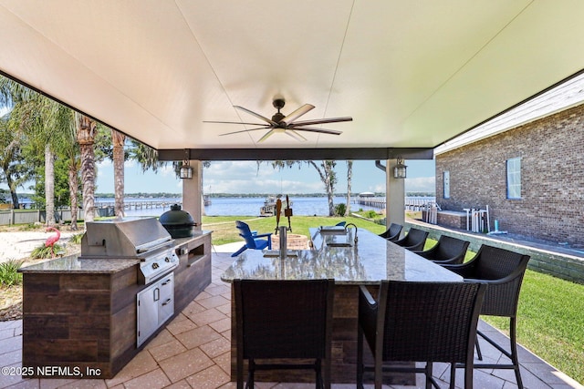 1833 N Lakeshore Dr, Fleming Island, FL 32003 - view of patio with a water view, ceiling fan, area for grilling, and an outdoor kitchen