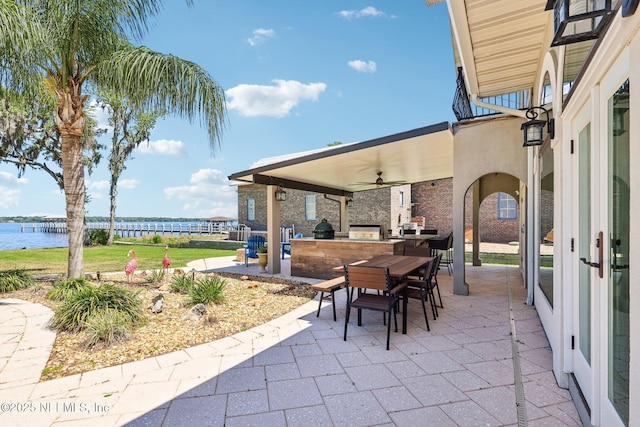 1833 N Lakeshore Dr, Fleming Island, FL 32003 - view of patio featuring outdoor dining area, a water view, ceiling fan, and exterior kitchen