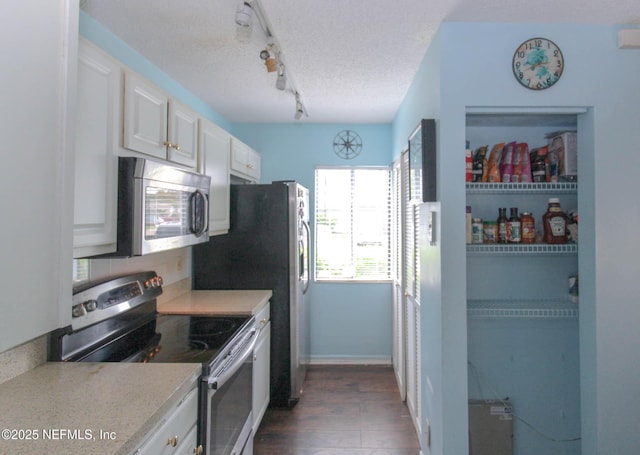 1403 Marsh Cove Ct, Ponte Vedra Beach, FL 32082 - kitchen with stainless steel appliances, rail lighting, dark wood-style flooring, light countertops, and white cabinetry