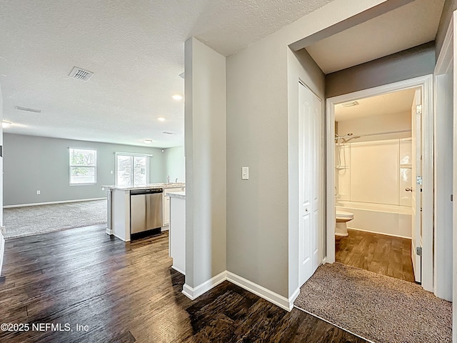 corridor with baseboards, visible vents, and dark wood finished floors