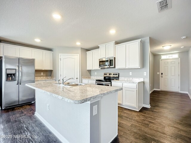 kitchen with dark wood-style flooring, appliances with stainless steel finishes, a sink, and light countertops