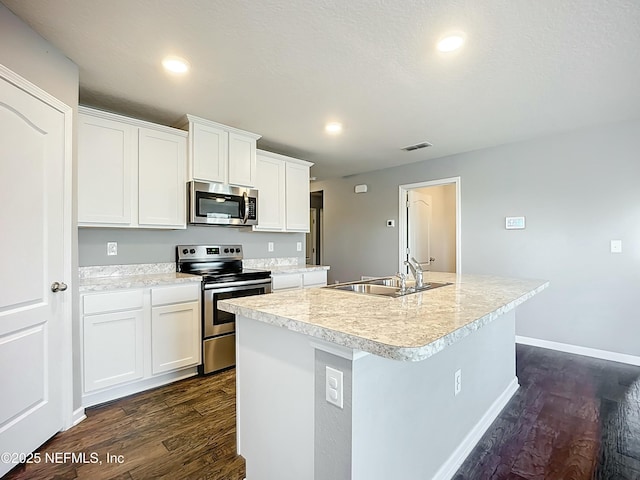 kitchen with dark wood-style floors, appliances with stainless steel finishes, a sink, and visible vents