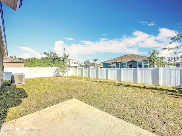 view of yard with a fenced backyard, central AC unit, and a patio