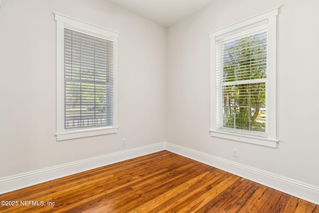 unfurnished room featuring baseboards and wood finished floors