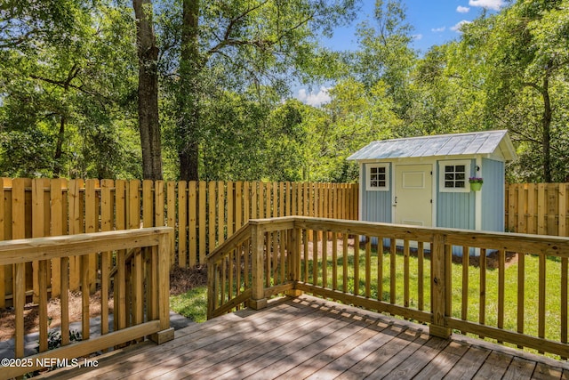 deck with a fenced backyard, an outdoor structure, and a shed