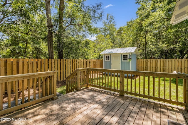 wooden deck with an outdoor structure, a yard, a storage shed, and a fenced backyard