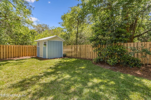 view of yard featuring an outbuilding, a shed, and a fenced backyard