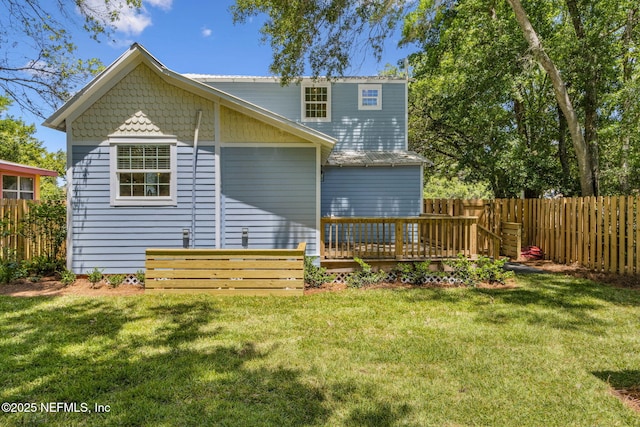 rear view of house featuring a fenced backyard, a yard, and a deck