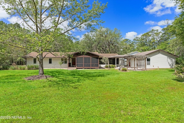 back of property with a sunroom, a pergola, and a yard