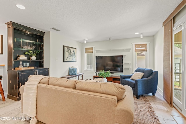 living area with a textured ceiling and recessed lighting