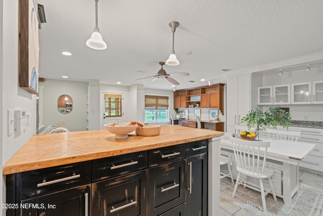 kitchen featuring dark cabinetry, butcher block countertops, a ceiling fan, pendant lighting, and recessed lighting