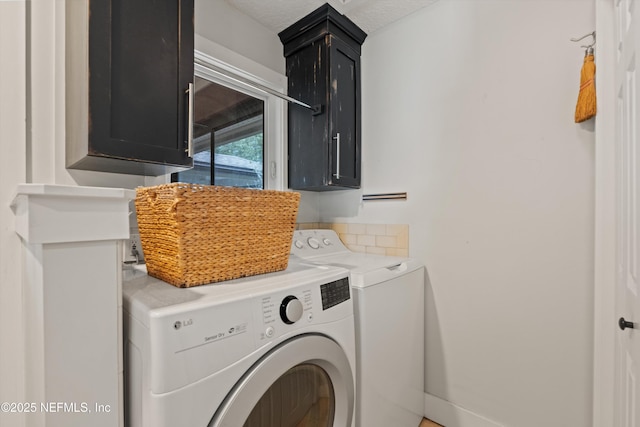 laundry area featuring washing machine and clothes dryer and cabinet space