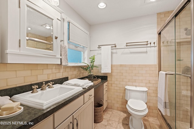 bathroom featuring tile walls, a shower stall, toilet, vanity, and recessed lighting