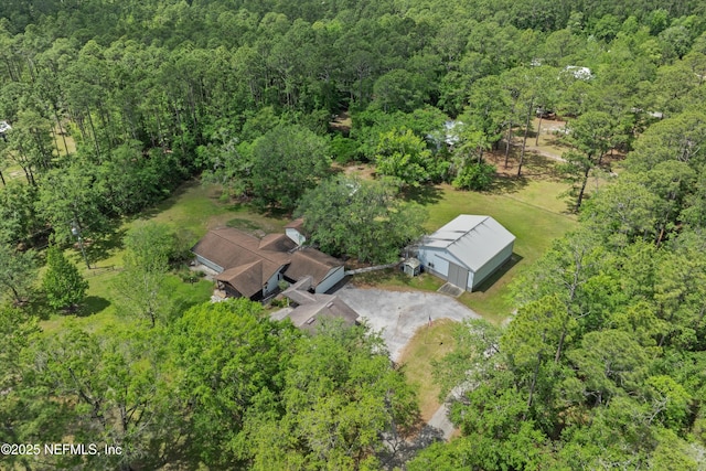 aerial view of property and surrounding area featuring a forest