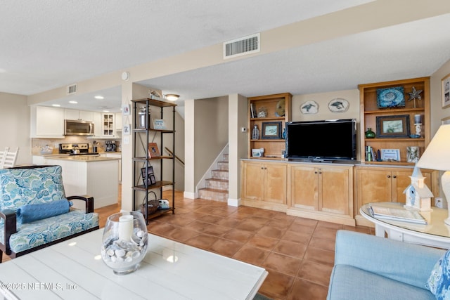 1029 Captains Court Dr Unit 1029, Fernandina Beach, FL 32034 - tiled living room featuring a textured ceiling, stairs, and baseboards