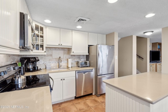 1029 Captains Court Dr Unit 1029, Fernandina Beach, FL 32034 - kitchen with stainless steel appliances, a sink, white cabinets, light countertops, and light tile patterned floors