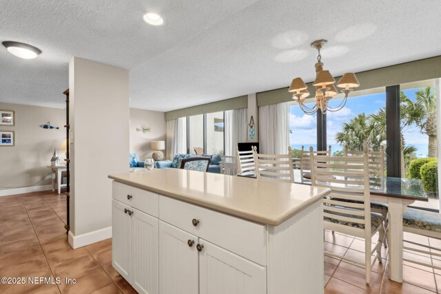 1029 Captains Court Dr Unit 1029, Fernandina Beach, FL 32034 - kitchen featuring a chandelier, light tile patterned floors, a textured ceiling, white cabinets, and baseboards