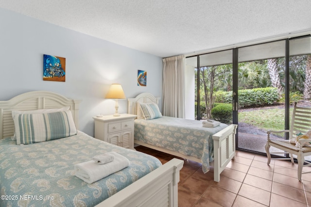 1029 Captains Court Dr Unit 1029, Fernandina Beach, FL 32034 - bedroom featuring floor to ceiling windows, access to exterior, light tile patterned floors, and a textured ceiling