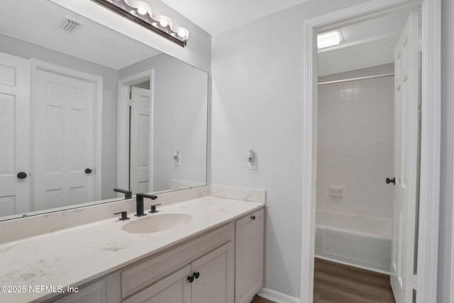 full bathroom featuring tub / shower combination, vanity, wood finished floors, and visible vents