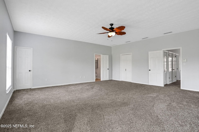 unfurnished bedroom with a ceiling fan, baseboards, ensuite bath, carpet flooring, and visible vents