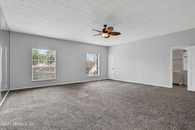 carpeted empty room featuring plenty of natural light, a textured ceiling, and ceiling fan
