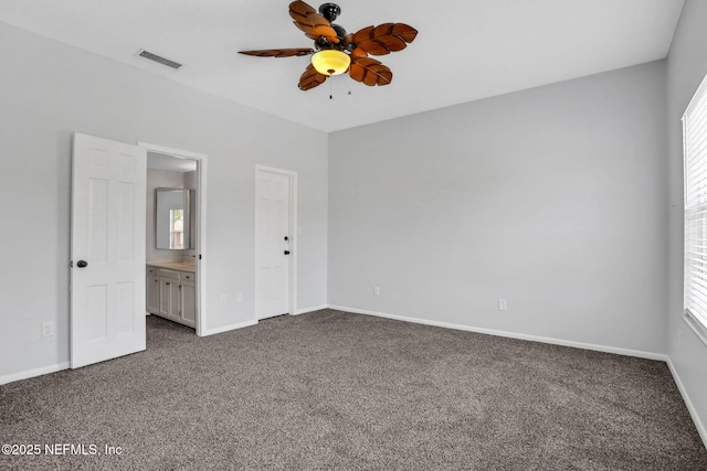 unfurnished bedroom with baseboards, dark colored carpet, and visible vents
