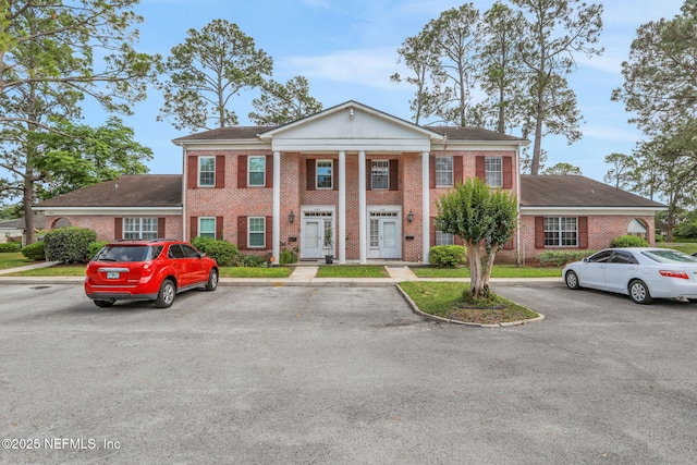 view of front of property with uncovered parking and brick siding