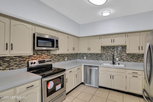 kitchen with light tile patterned flooring, light countertops, appliances with stainless steel finishes, and a sink