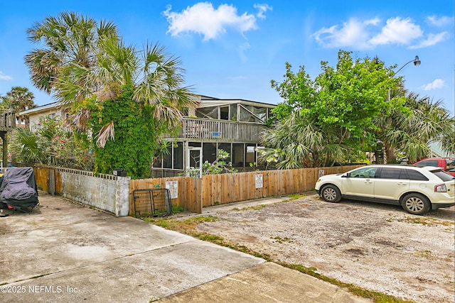 view of front of house with a fenced front yard, a gate, and a balcony