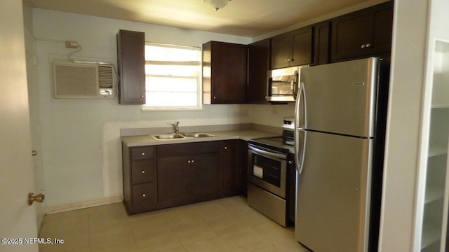 kitchen featuring light tile patterned floors, a sink, stainless steel appliances, light countertops, and dark brown cabinetry