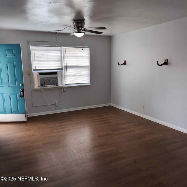 interior space featuring wood finished floors, a ceiling fan, cooling unit, and baseboards