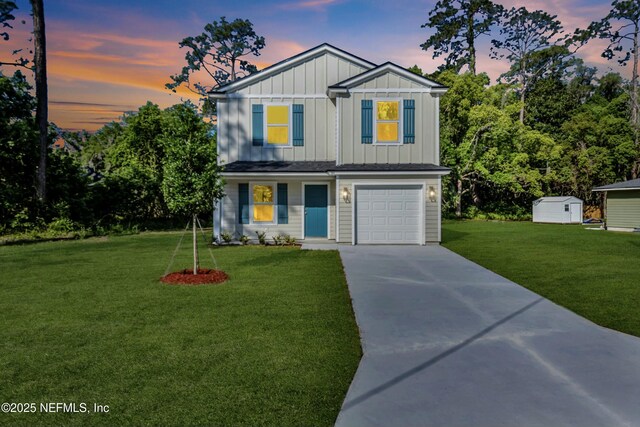 traditional-style home featuring a storage shed, concrete driveway, board and batten siding, a lawn, and a garage