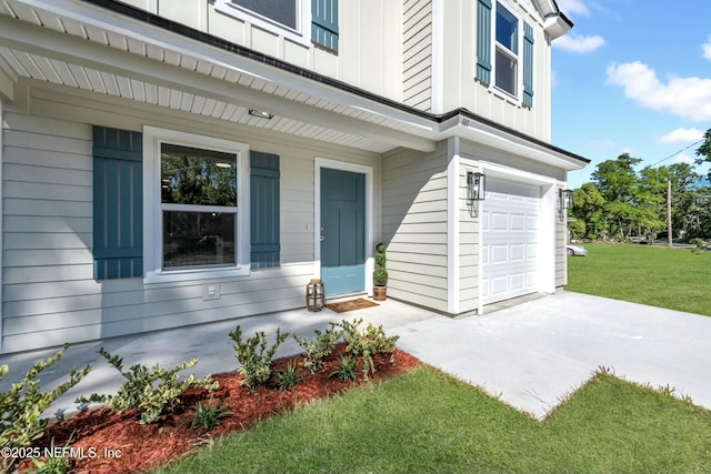 view of exterior entry featuring a garage, a lawn, and board and batten siding