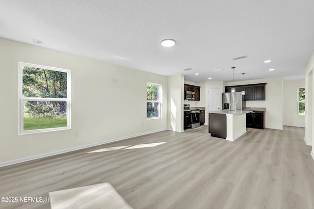 unfurnished living room featuring visible vents, light wood-style flooring, baseboards, and recessed lighting