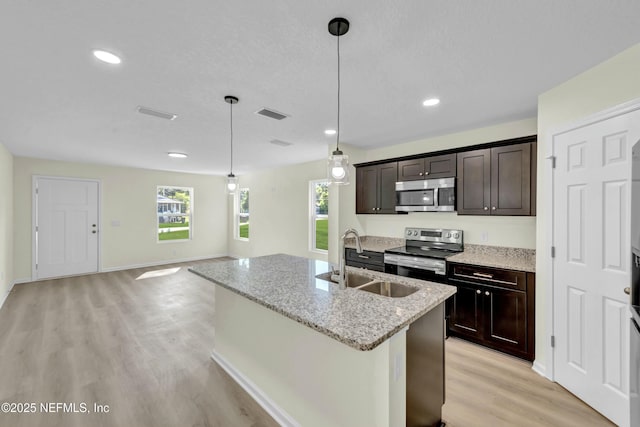 kitchen featuring a sink, light wood-style floors, appliances with stainless steel finishes, and a healthy amount of sunlight