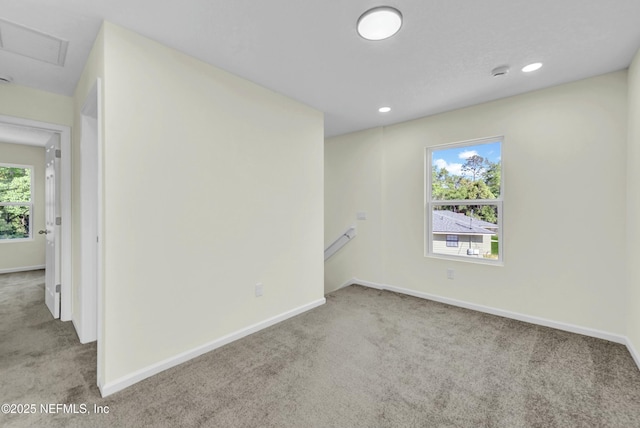 unfurnished room with attic access, carpet, baseboards, visible vents, and recessed lighting