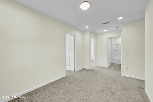 carpeted empty room featuring baseboards, visible vents, and recessed lighting
