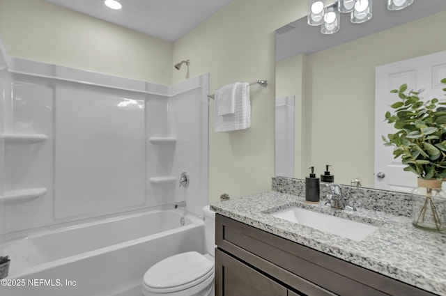 bathroom with toilet, vanity, and  shower combination