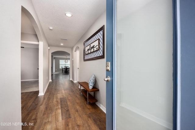 19533 NW 229th St, High Springs, FL 32643 - corridor with arched walkways, dark wood-style flooring, a textured ceiling, and recessed lighting