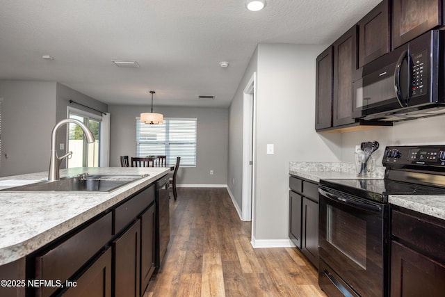 19533 NW 229th St, High Springs, FL 32643 - kitchen featuring black appliances, dark brown cabinetry, wood finished floors, light countertops, and pendant lighting
