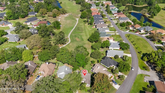 drone / aerial view featuring a residential view, golf course view, and a water view