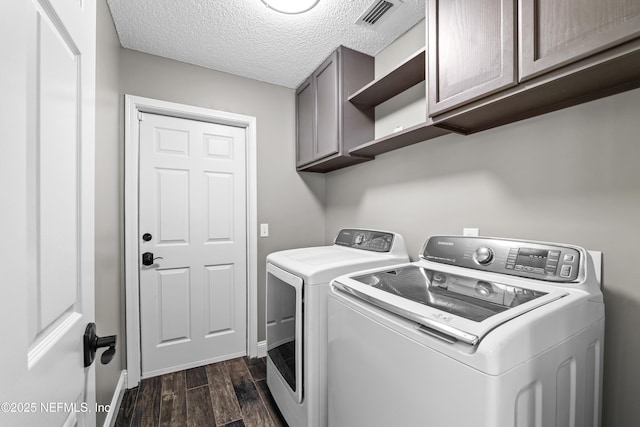 laundry room featuring dark wood-style flooring, washing machine and dryer, baseboards, visible vents, and cabinet space