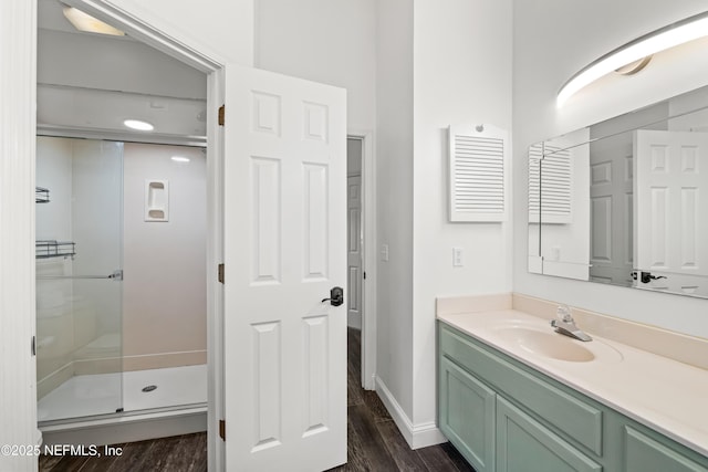 bathroom with a shower stall, baseboards, vanity, and wood finished floors